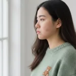 wanita menatap jendela dengan wajah sedih, butuh antibiotik jerawat (Image Concept by Homey Button)